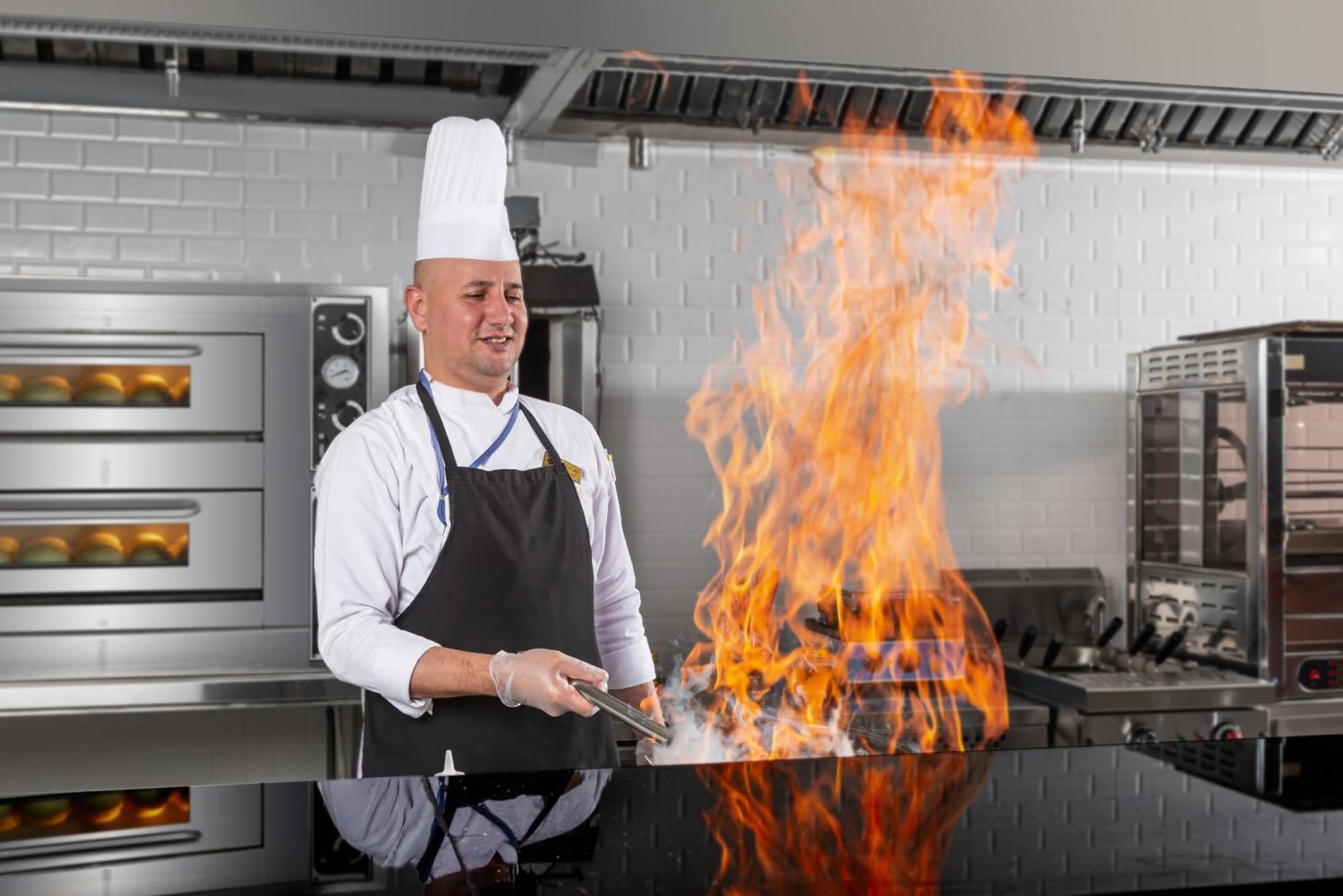 Nivel Hotel Abha Khamis Mushait Exterior photo A chef flambéing a dish